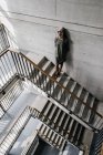 Woman with long grey hair leaning against wall on staircase — Stock Photo