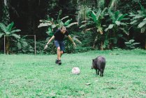 Peru, Homem jogando futebol com um peccary — Fotografia de Stock