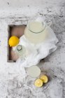 Limonata in brocca e bicchieri sulla superficie di marmo — Foto stock