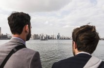 Deux hommes d'affaires debout à East River, New York, États-Unis — Photo de stock