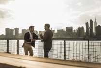 Двоє бізнесменів, які говорять на Іст-Рівер, Нью-Йорк, США — стокове фото