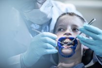 Garçon en chirurgie dentaire recevant un traitement orthodontique — Photo de stock