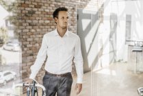 Бізнесмен з велосипедні прогулянки у сучасні офісні — стокове фото