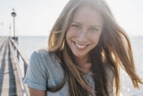 Retrato de una joven feliz en el embarcadero a contraluz - foto de stock