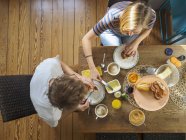 Giovane coppia seduta a tavola e fare colazione — Foto stock