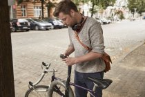 Homme verrouillage vélo dans la ville — Photo de stock