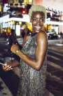 Happy african american woman on Times Square at nighttime, NY, USA — Stock Photo