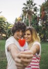 Giovane coppia in possesso di lecca-lecca a forma di cuore — Foto stock