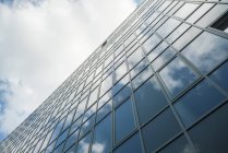 Façade moderne en verre réfléchissant les nuages — Photo de stock