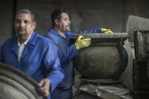 Due uomini che lavorano nella fabbrica di pentole industriali — Foto stock