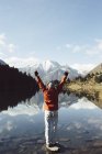 Франция, Пьес, Карлит, турист, поднимающий руки на горном озере — стоковое фото