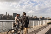 Zwei Geschäftsleute mit Fahrrad entlang des East River, New York City, USA — Stockfoto