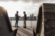 Deux hommes d'affaires discutant à East River, New York, USA — Photo de stock
