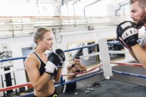 Mujer caucásica boxeador sparring con entrenador - foto de stock