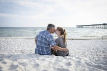 Estados Unidos, Pareja besándose sentada en Panama City Beach - foto de stock