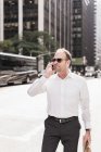 USA, New York City, businessman walking in Manhattan on cell phone — Stock Photo