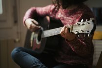 Young woman playing guitar at home — Stock Photo