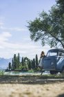 Italien, Gardasee, junge Frau trinkt Kaffee im Campingbus — Stockfoto
