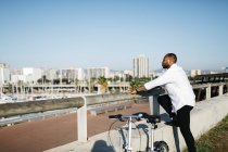 Homme debout à côté de vélo et regardant la vue — Photo de stock