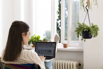 Caucasian brunette woman using laptop at home — Stock Photo
