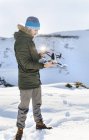 Hombre con dron volador en montañas nevadas - foto de stock