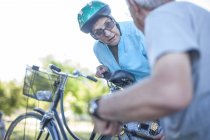 Mujer mayor en bicicleta hablando con el hombre - foto de stock