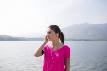 Italia, Lecco, giovane sportiva in riva al lago ad ascoltare musica — Foto stock