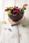 Closeup view of leaf salad with edible flowers in bowl — Stock Photo