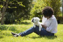 Donna seduta sul prato con cane — Foto stock