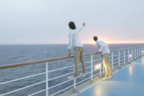 Junge Männer stehen an Deck des Schiffes und beobachten den Sonnenuntergang — Stockfoto