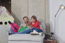 Glückliche dreiköpfige Familie entspannt zu Hause — Stockfoto