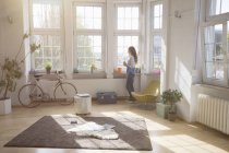 Woman at home looking out of window — Stock Photo