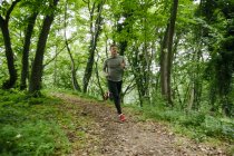 Junger Mann läuft in Wald — Stockfoto