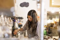 Jeune femme travaillant dans son propre petit café — Photo de stock