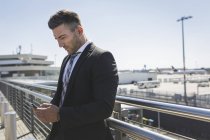 Businessman with cell phone at airport — Stock Photo