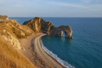 Inghilterra, Jurassic Coast, Durdle Door, arco di roccia, spiaggia alla calda luce della sera — Foto stock