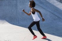 Молода жінка біжить у скейтпарку — стокове фото