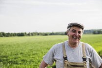 Retrato del granjero sonriente en un campo - foto de stock