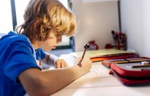 Portrait of pensive boy doing homework at home — Stock Photo