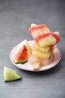 Plate with stack of different homemade melon ice lollies — Stock Photo