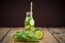 Glass bottle of table water flavored with basil and cucumber — Stock Photo