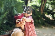 Мать и маленький сын в масках животных играют в парке — стоковое фото