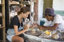 Homme et femme en atelier travaillant sur la poterie — Photo de stock