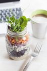 Regenbogensalat im Glas mit Kaffeebecher und Laptop — Stockfoto
