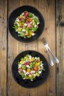 Salad bowls with lamb lettuce, quinoa, yellow bell pepper, cocktail tomato, avocado, feta and pomegranate seeds — Stock Photo