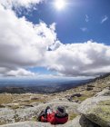 Spagna, Sierra de Gredos, Escursionista vista posteriore seduto sulla roccia guardando la mappa in pieno sole — Foto stock