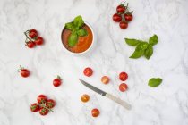 Minestra di pomodoro con pomodori e coltello su marmo — Foto stock