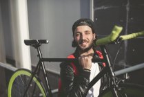 Souriant jeune homme portant vélo fixie — Photo de stock