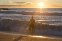 Surfista che esce dal mare all'alba — Foto stock
