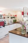 Кухня с цветами на острове кухни в помещении — стоковое фото